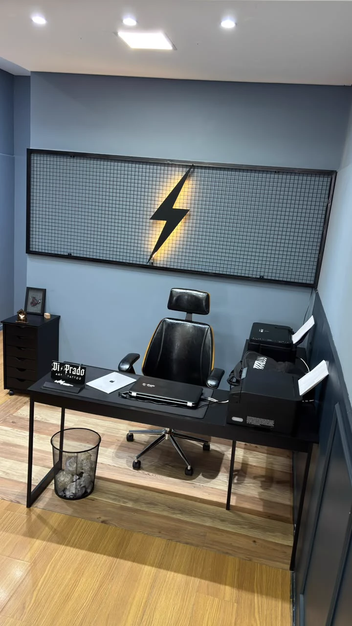 Recepção do estúdio Di Prado Tattoo com painel iluminado