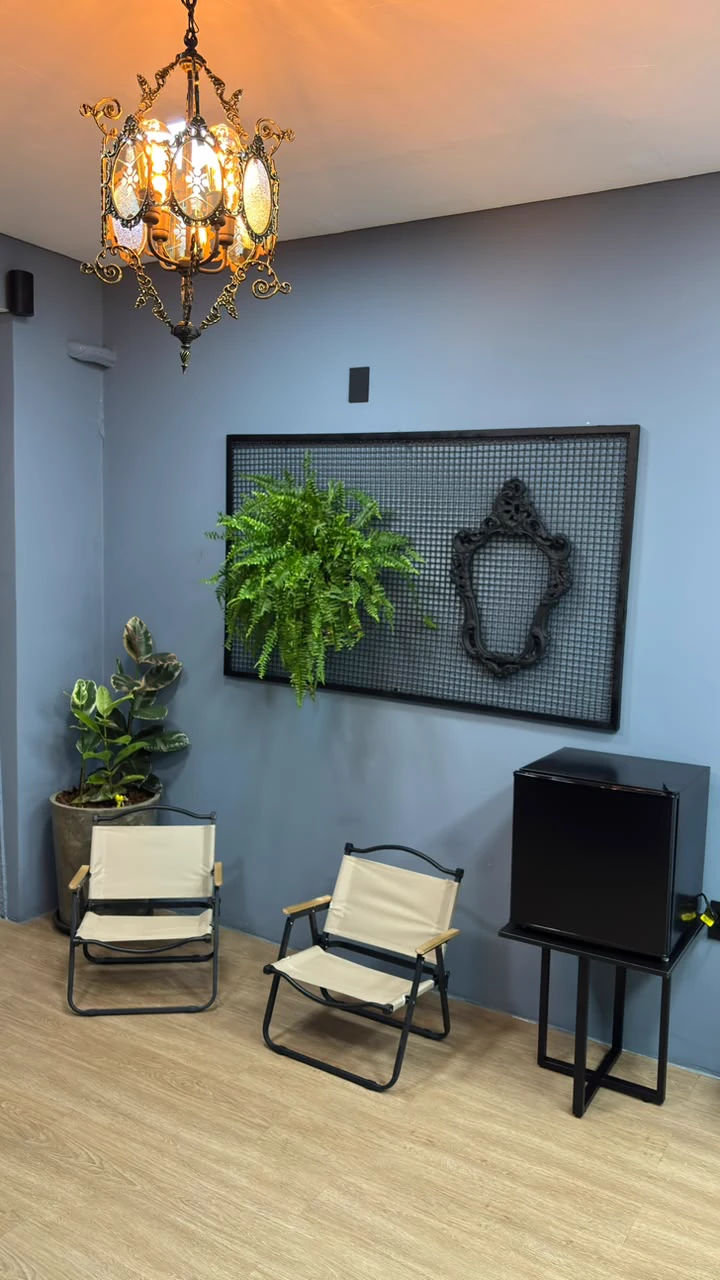 Área de espera do estúdio Di Prado Tattoo com plantas e poltronas